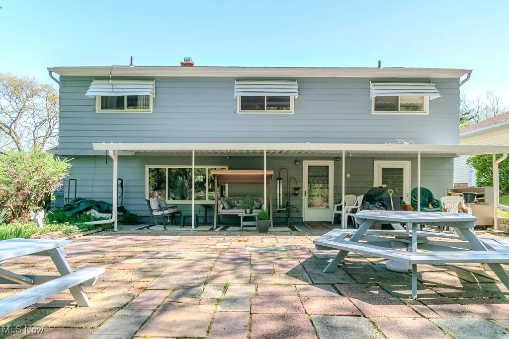Rear view of house with a patio and outdoor dining space
