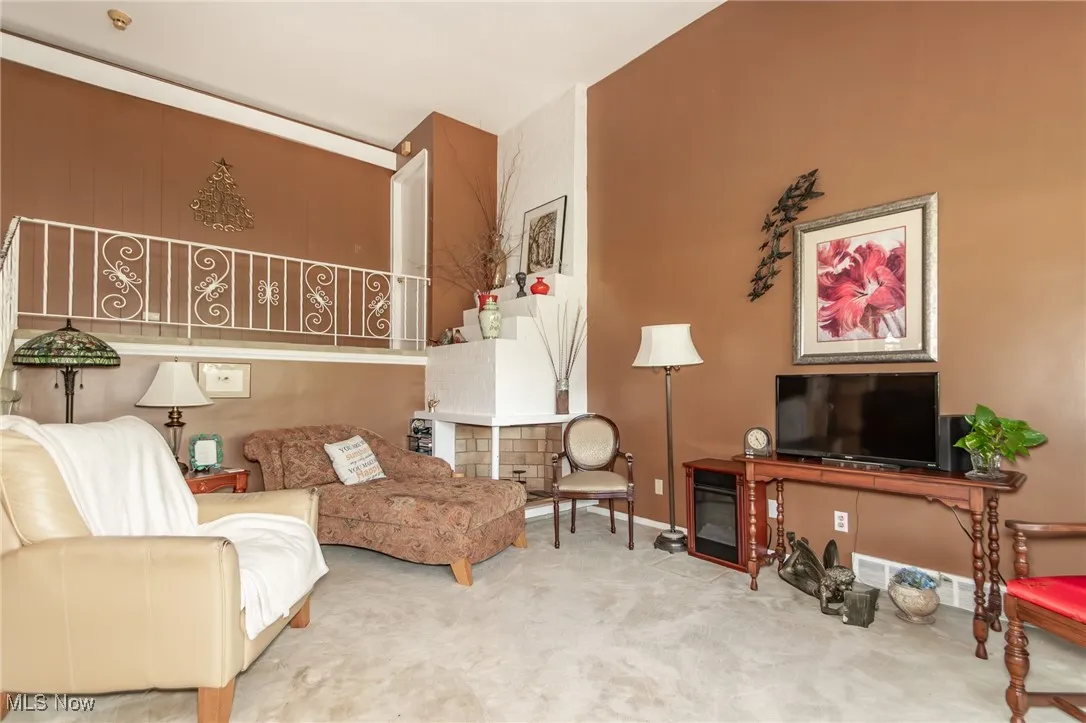 Living area with baseboards and carpet