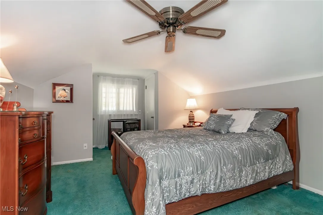 Bedroom featuring vaulted ceiling, baseboards, ceiling fan, and carpet flooring