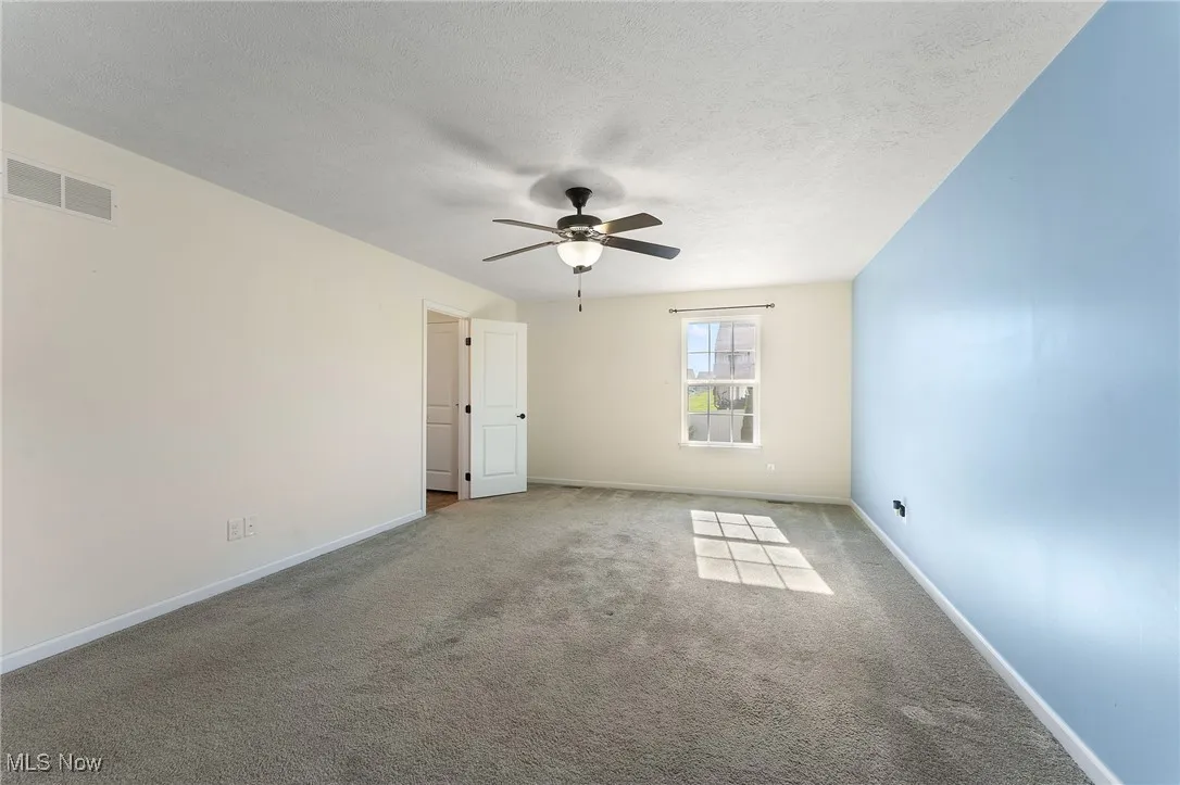 Master bedroom featuring visible vents, a ceiling fan, carpet, and baseboards