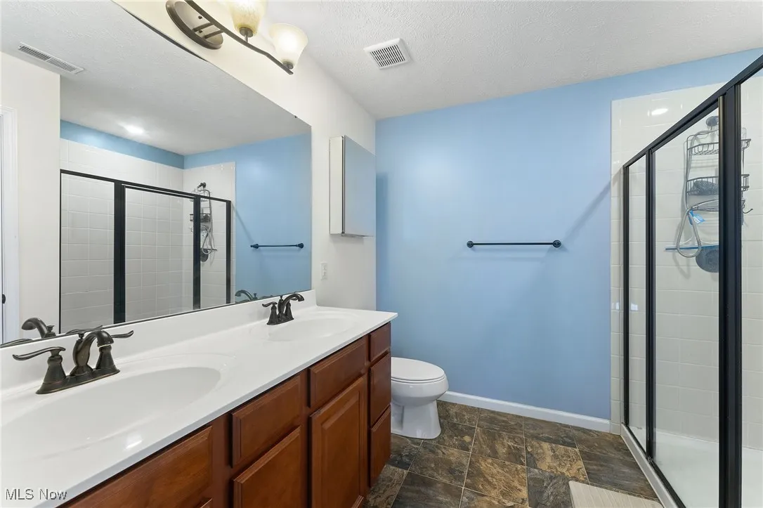 Master Full bathroom with visible vents, a sink, and a stall shower