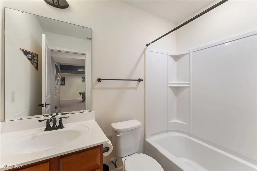 Bathroom with toilet, washtub / shower combination, and vanity