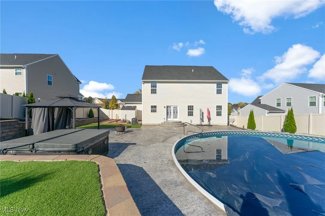 View of swimming pool featuring a gazebo, a fenced backyard, a residential view, and a patio