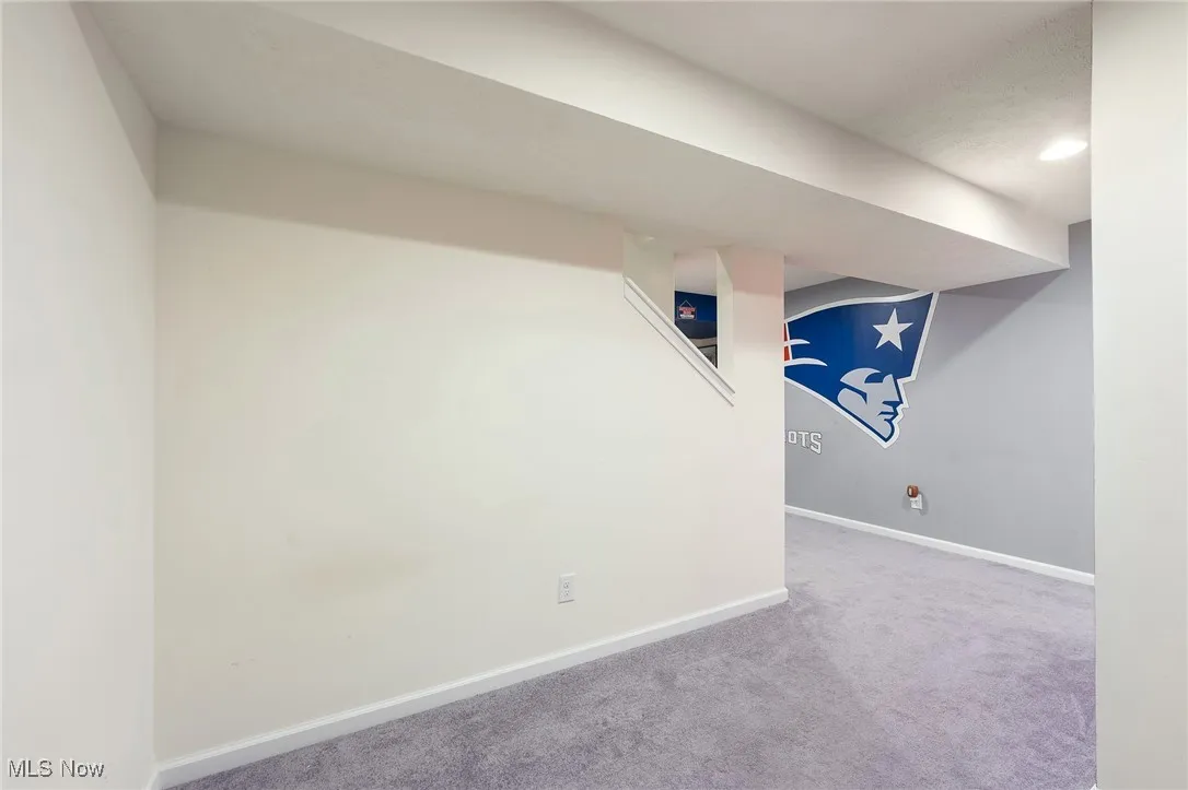 Finished basement with baseboards and carpet