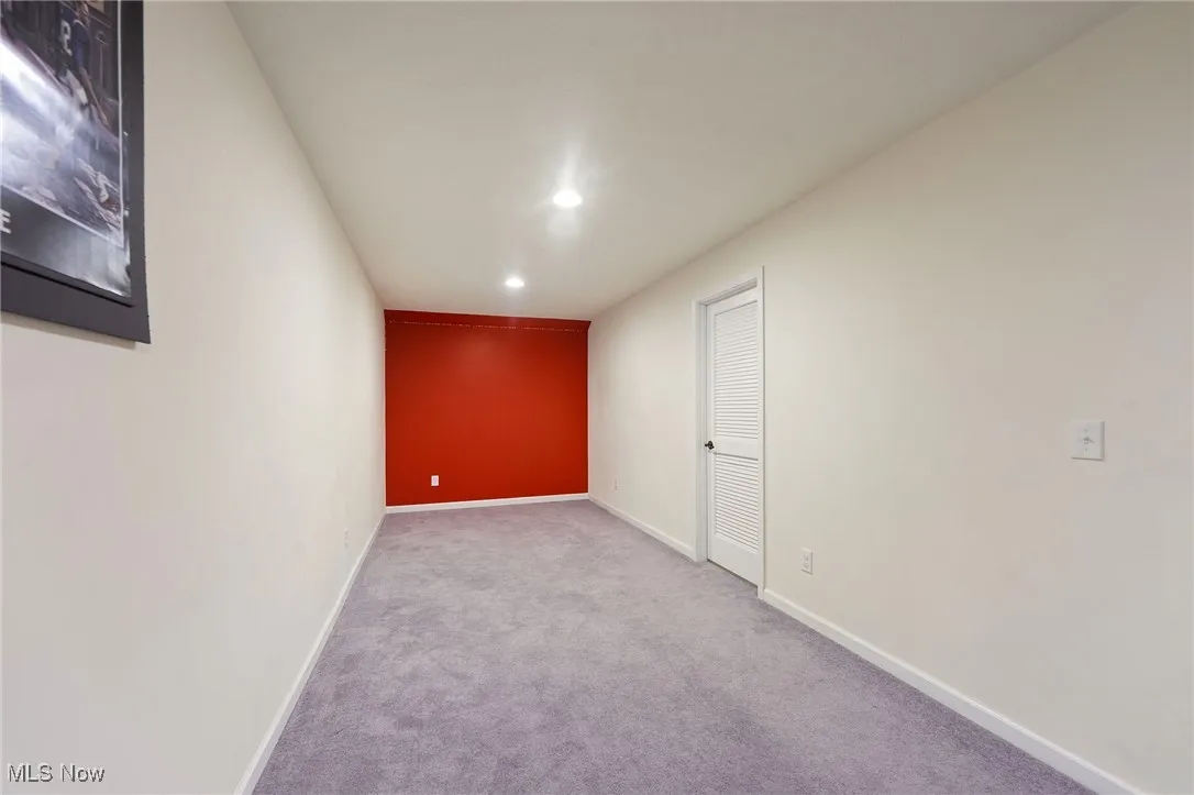 Carpeted empty room featuring recessed lighting and baseboards