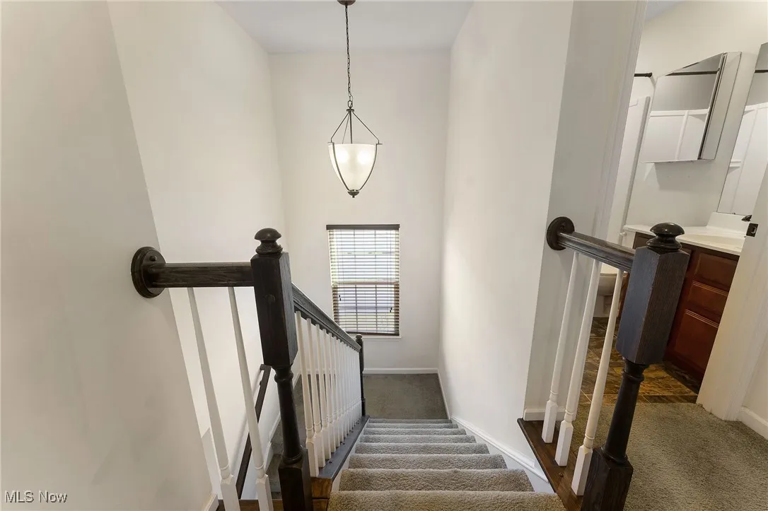 Spare room featuring stairs, ceiling fan, baseboards, and light wood finished floors