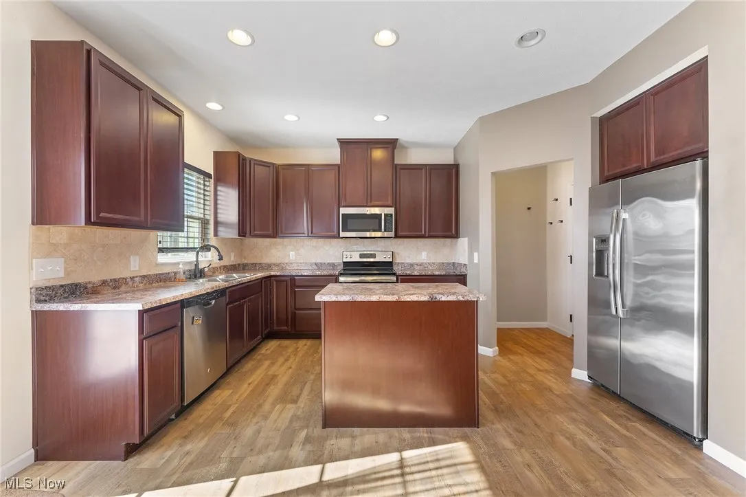 Kitchen with a kitchen island, appliances with stainless steel finishes, and light wood-type flooring