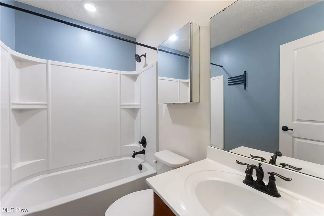 Full bathroom featuring toilet, shower / washtub combination, and vanity