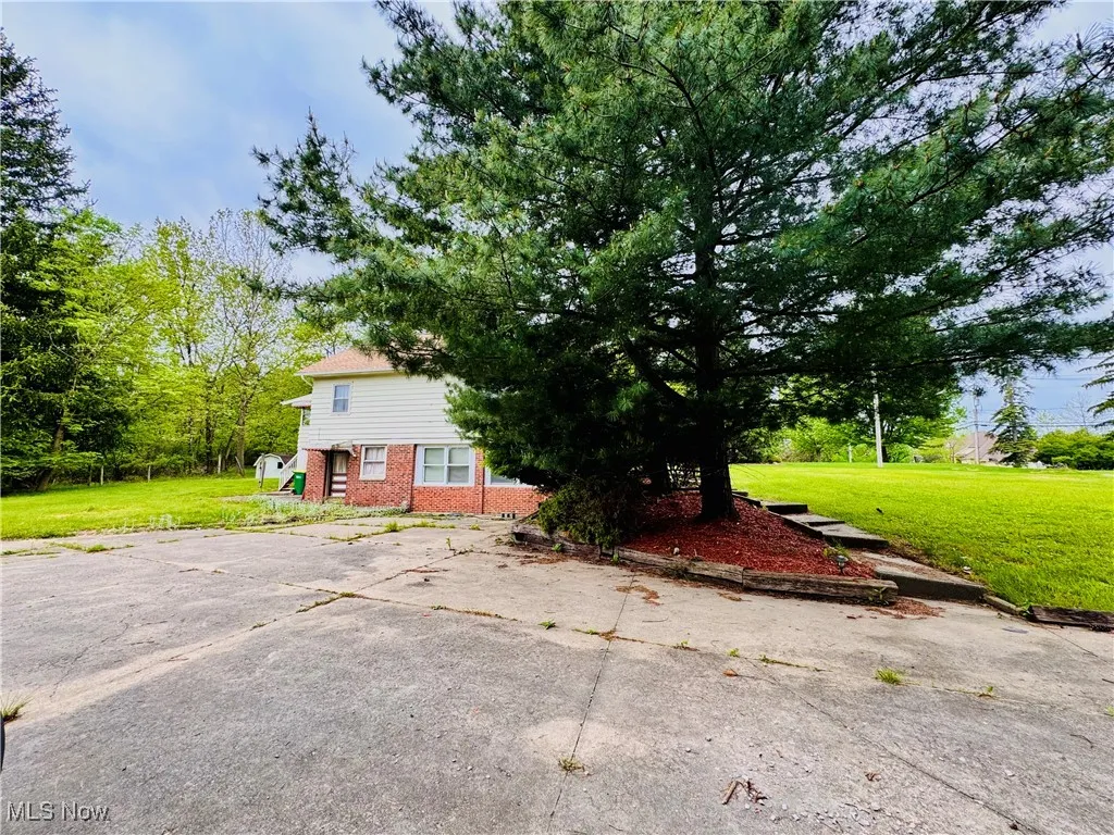View of side of property with brick siding and  side and fron lawn