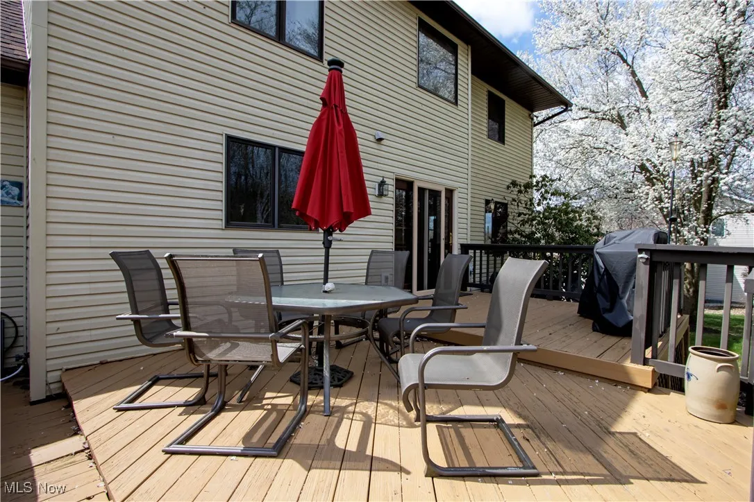 Wooden terrace featuring grilling area and outdoor dining space
