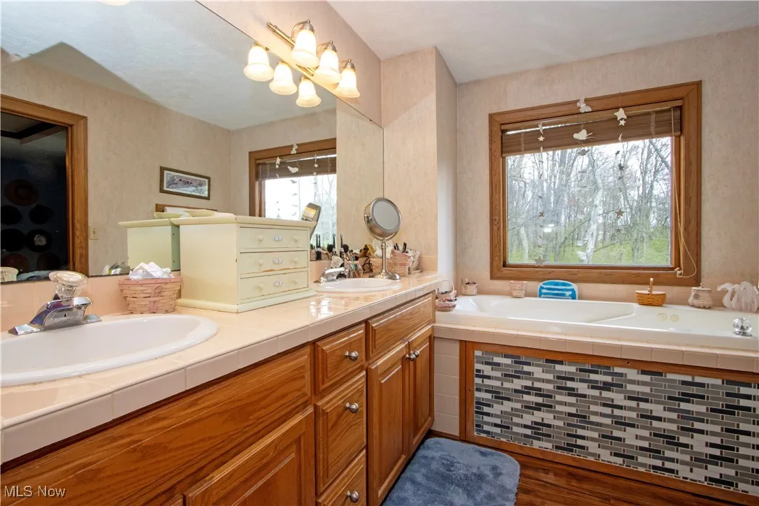 Full bathroom featuring a sink, a garden tub, and double vanity
