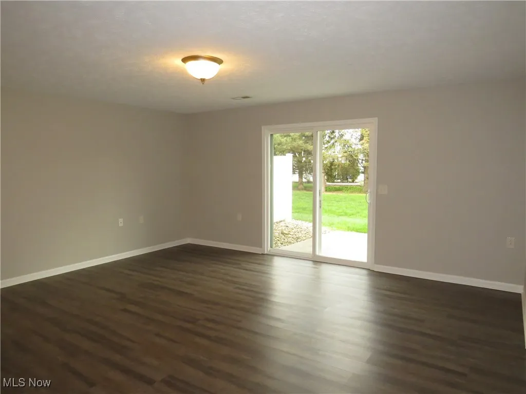 Living Room featuring baseboards and dark wood-style flooring