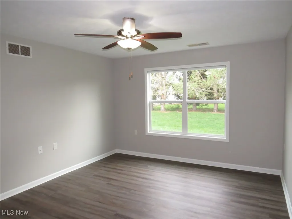 Spare room featuring a wealth of natural light, a ceiling fan, and visible vents