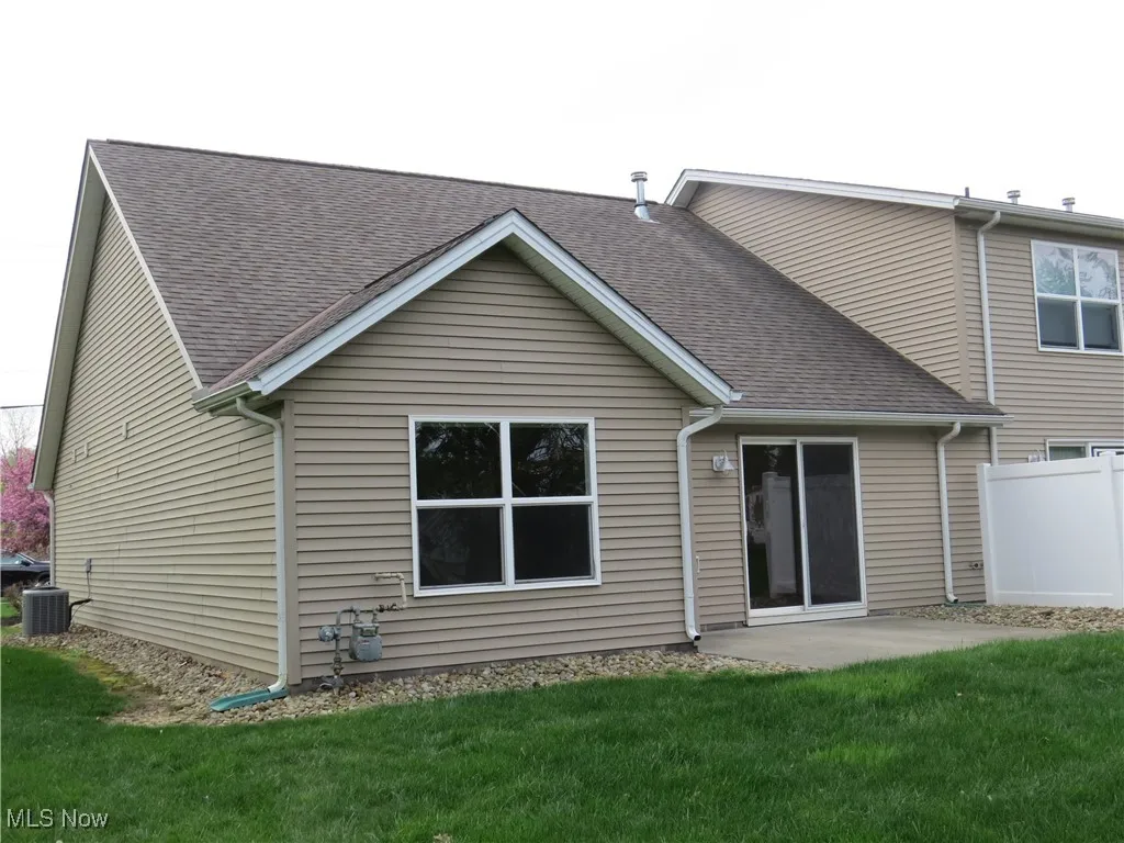 Back of house with a lawn, central AC, fence, a patio, and a shingled roof