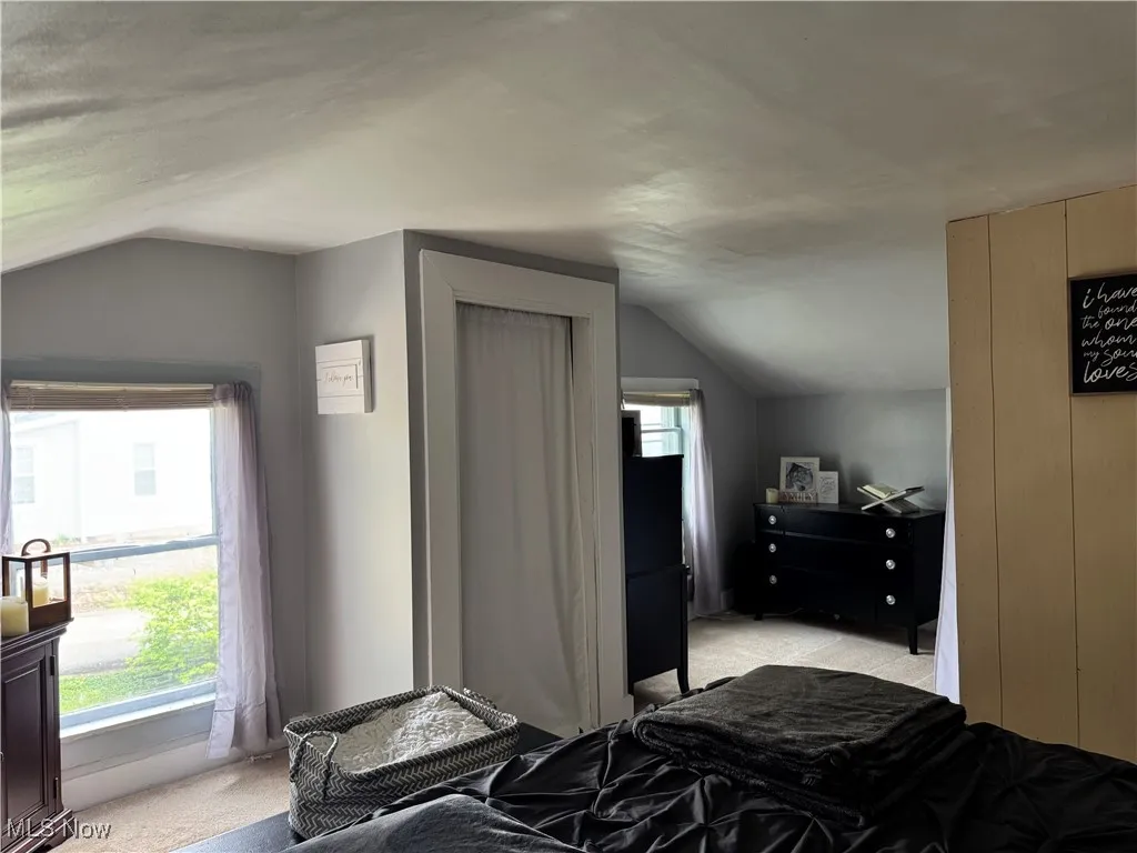 Bedroom featuring vaulted ceiling and light colored carpet