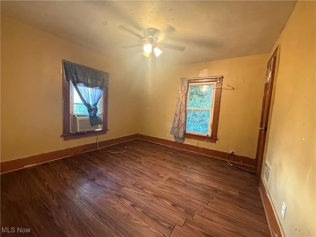 Spare room featuring dark wood finished floors and a ceiling fan
