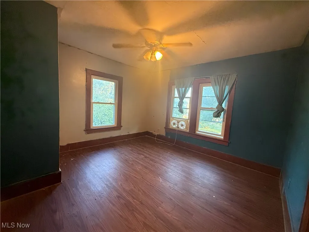 Spare room featuring dark wood-style floors and ceiling fan