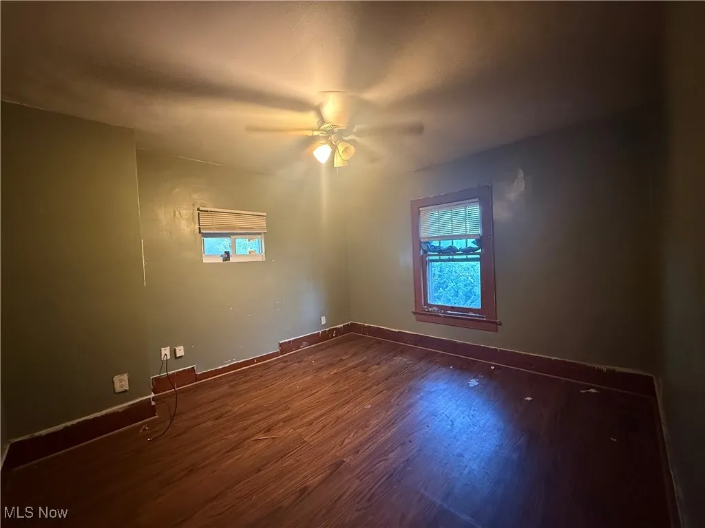 Spare room featuring wood finished floors and a ceiling fan