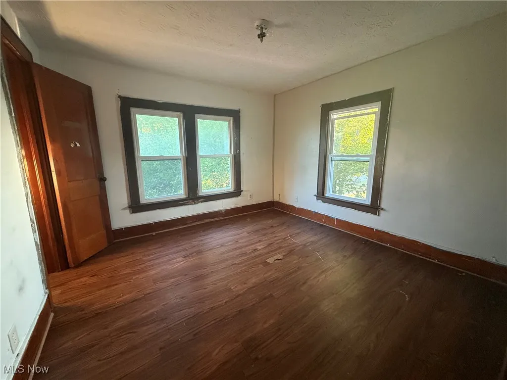 Spare room with dark wood-style flooring and a textured ceiling