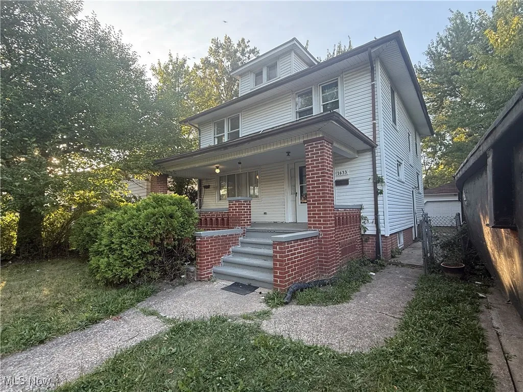 American foursquare style home featuring covered porch and a gate