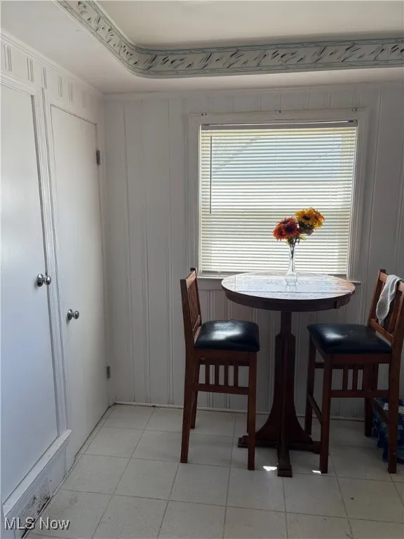 Dining room with a decorative wall and light tile patterned flooring