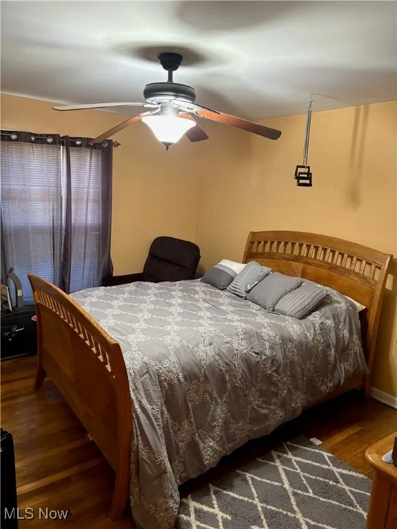 Bedroom with a ceiling fan, baseboards, and wood finished floors