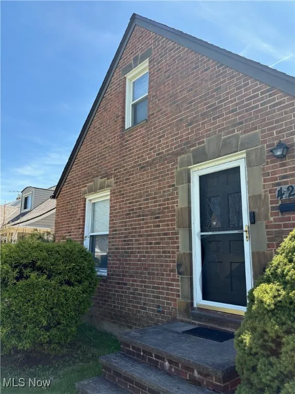 View of property exterior with brick siding