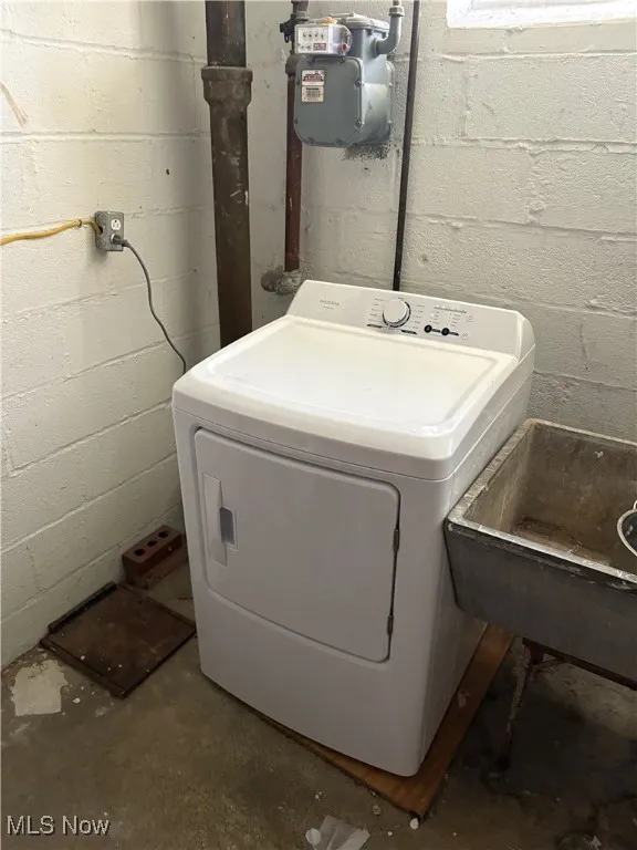 Clothes washing area with washer / clothes dryer and concrete block wall