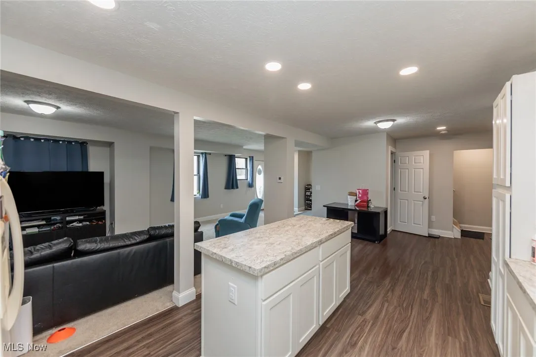Kitchen featuring light countertops, white cabinetry, and dark wood-style floors