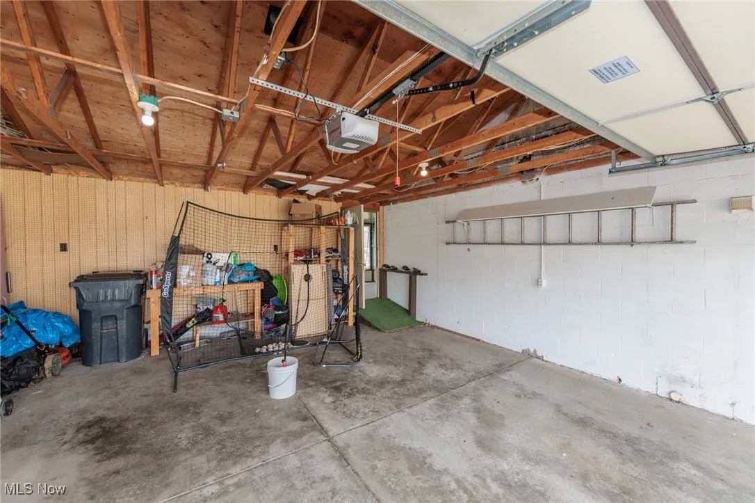 Garage featuring a garage door opener and visible vents