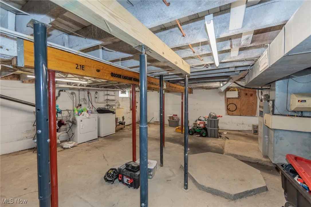 Unfinished basement with a sink and independent washer and dryer