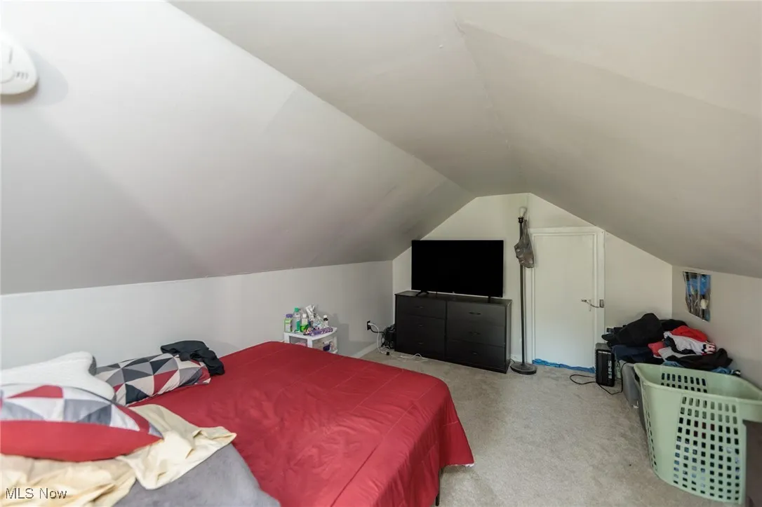 Carpeted bedroom featuring lofted ceiling