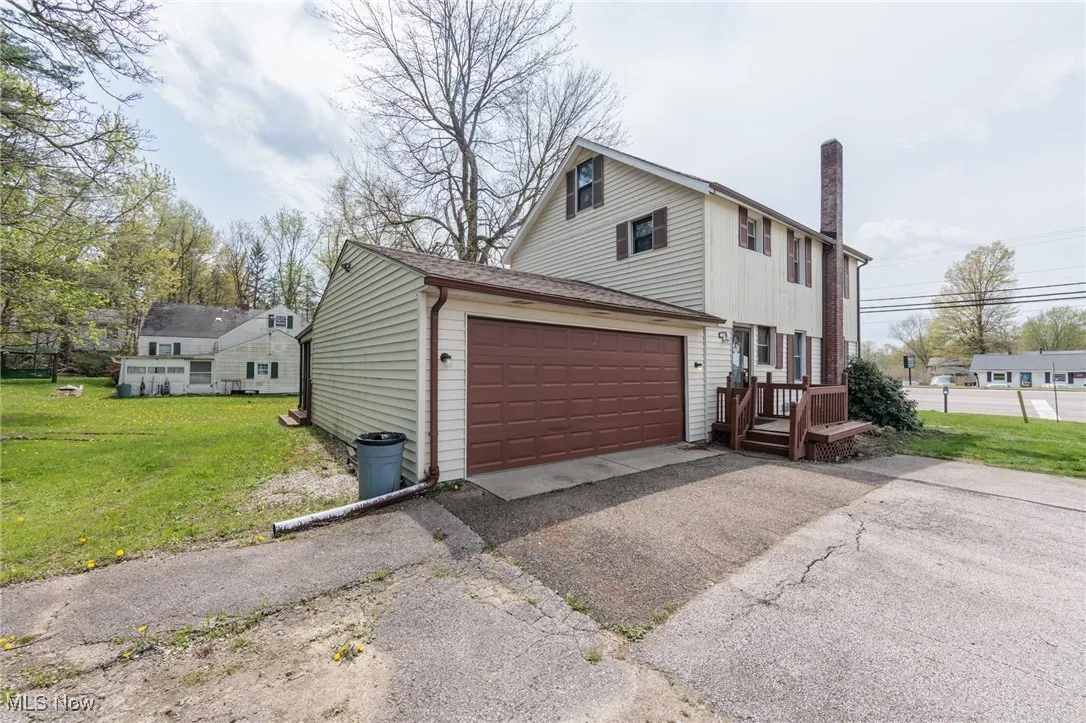 View of side of property with a lawn, aphalt driveway, and a chimney