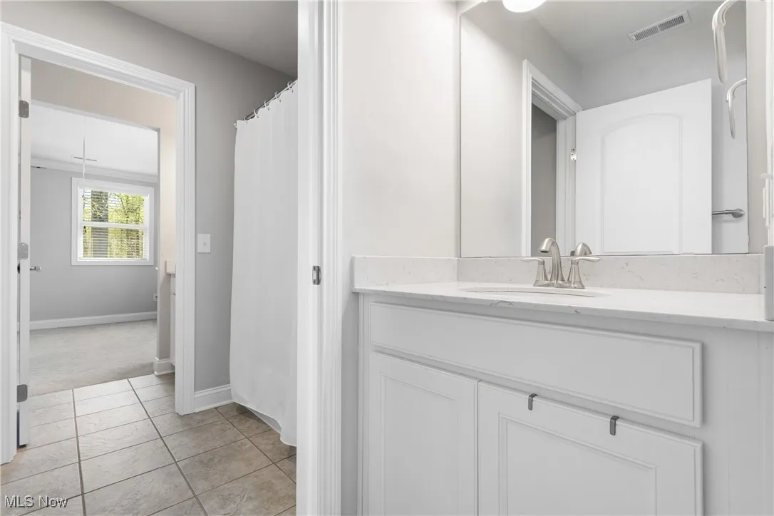 Full bath with vanity, baseboards, tile patterned flooring, and visible vents
