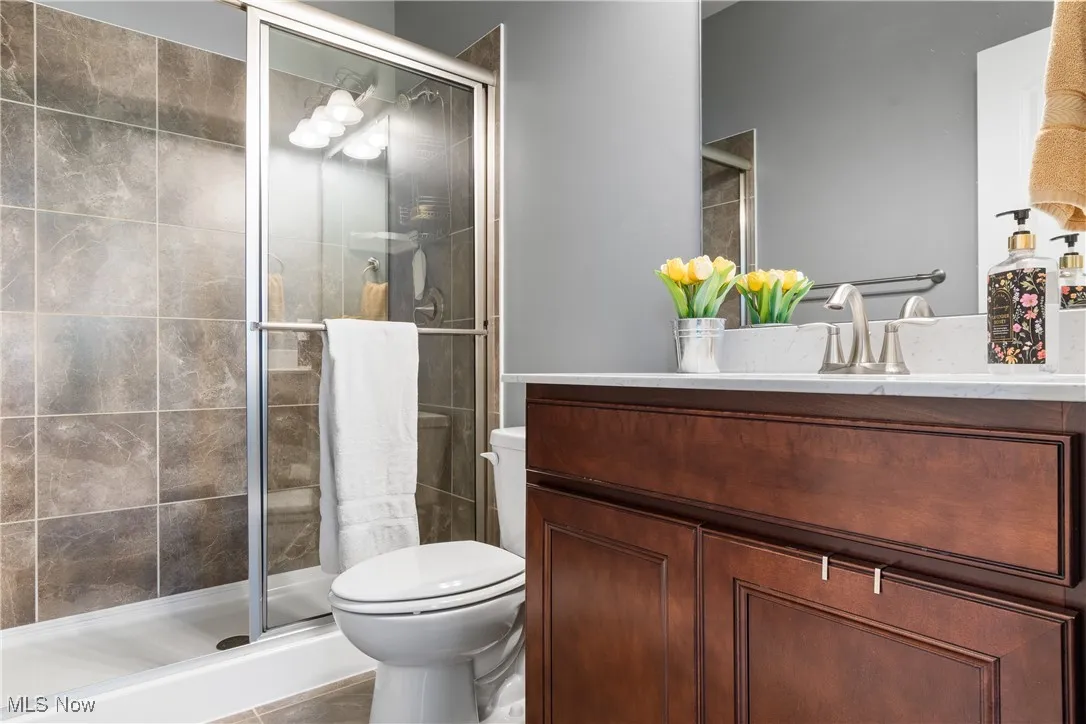1st floor full Bathroom featuring vanity, toilet, and a stall shower