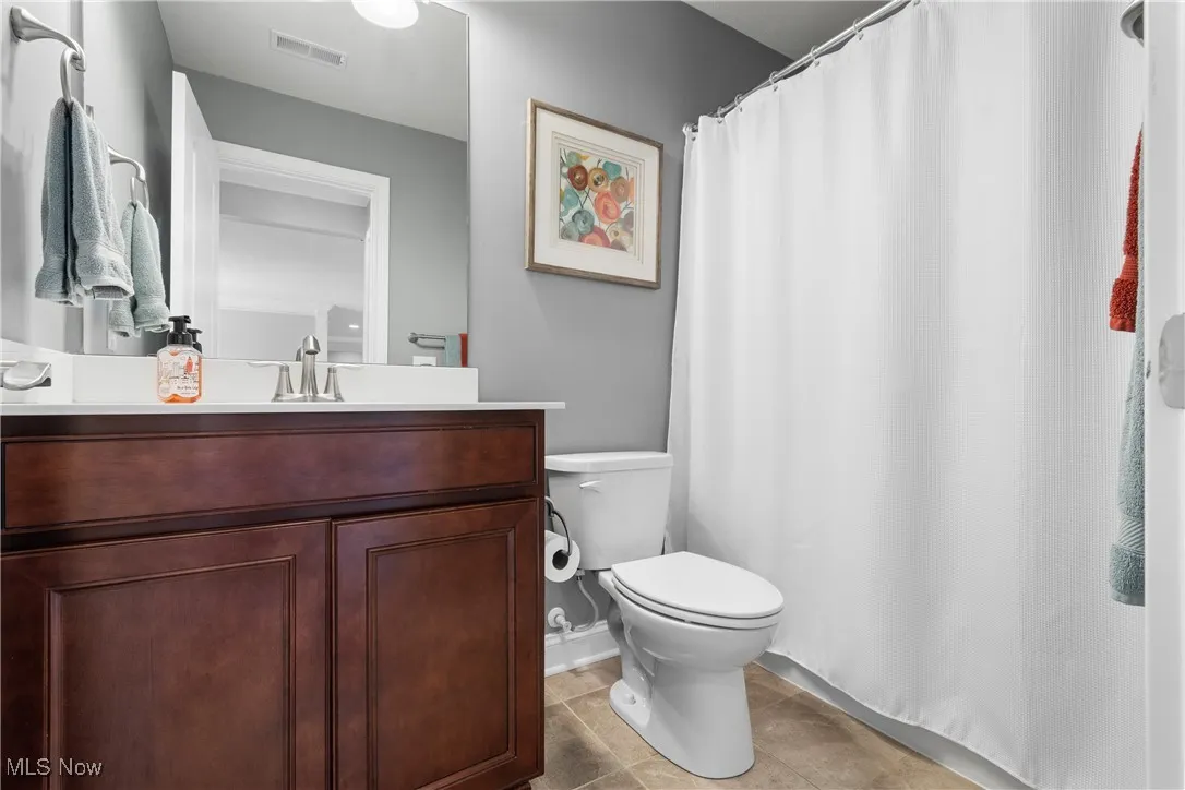 Full bath with visible vents, toilet, and vanity