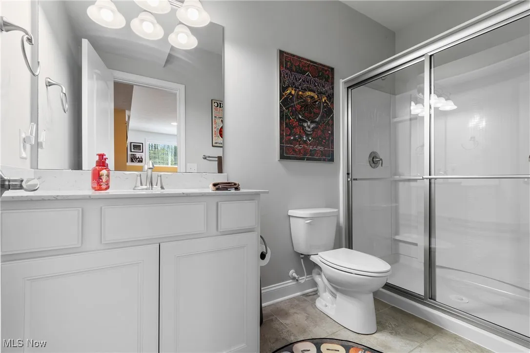 Bathroom featuring baseboards, toilet, and a shower stall