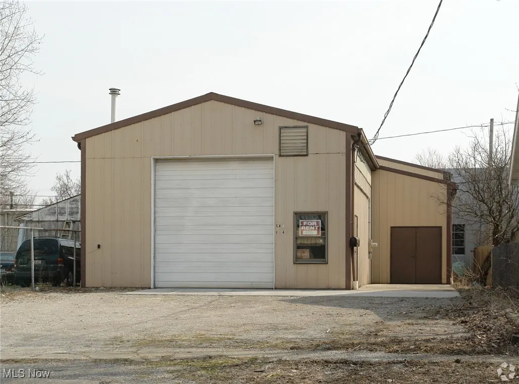Detached garage featuring dirt driveway