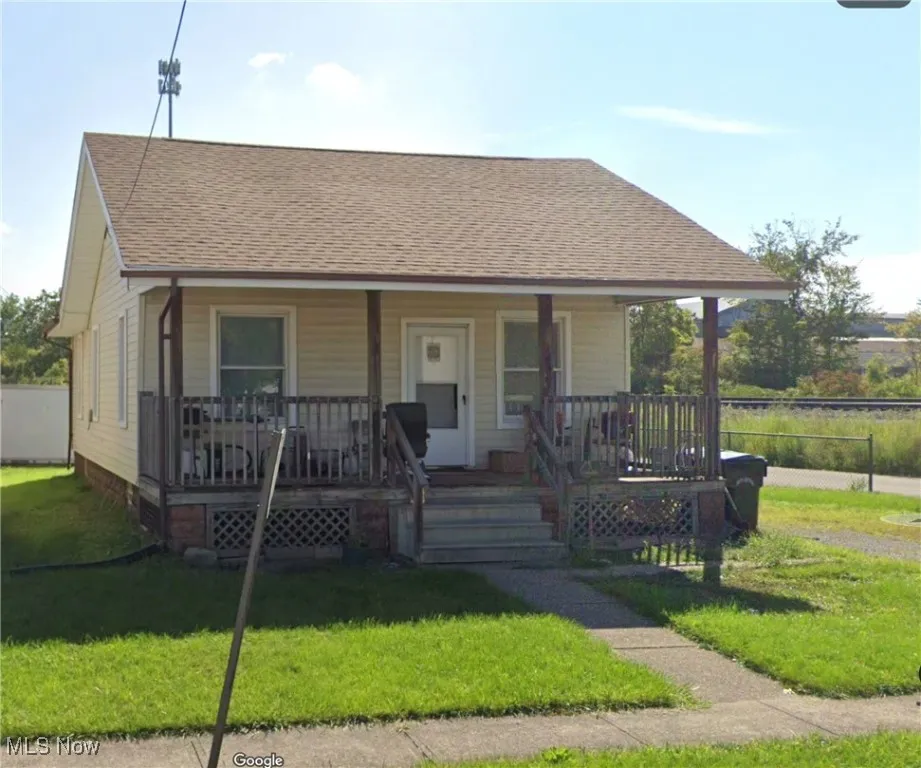 Bungalow-style home featuring a porch, a front yard, and roof with shingles