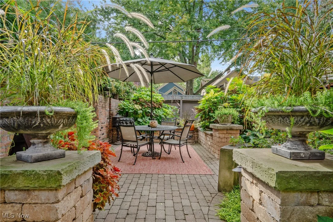 View of courtyard patio featuring brick privacy wall, fence and outdoor entertainment space