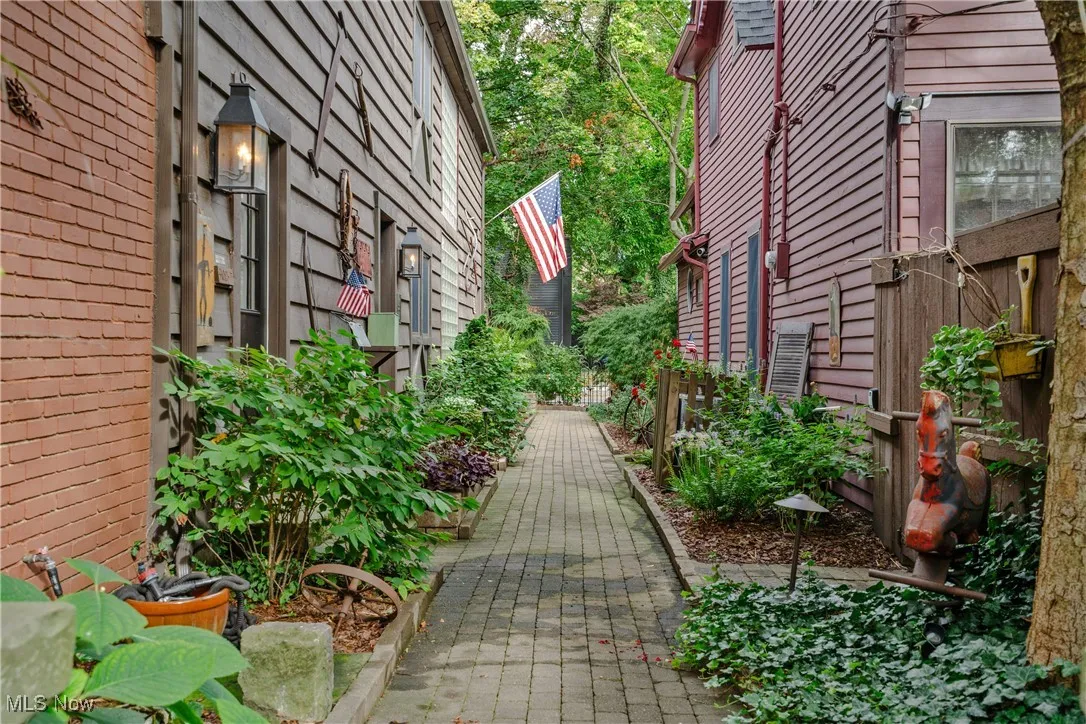 View of left side of property and brick paver walkway from the courtyard looking towards the street
