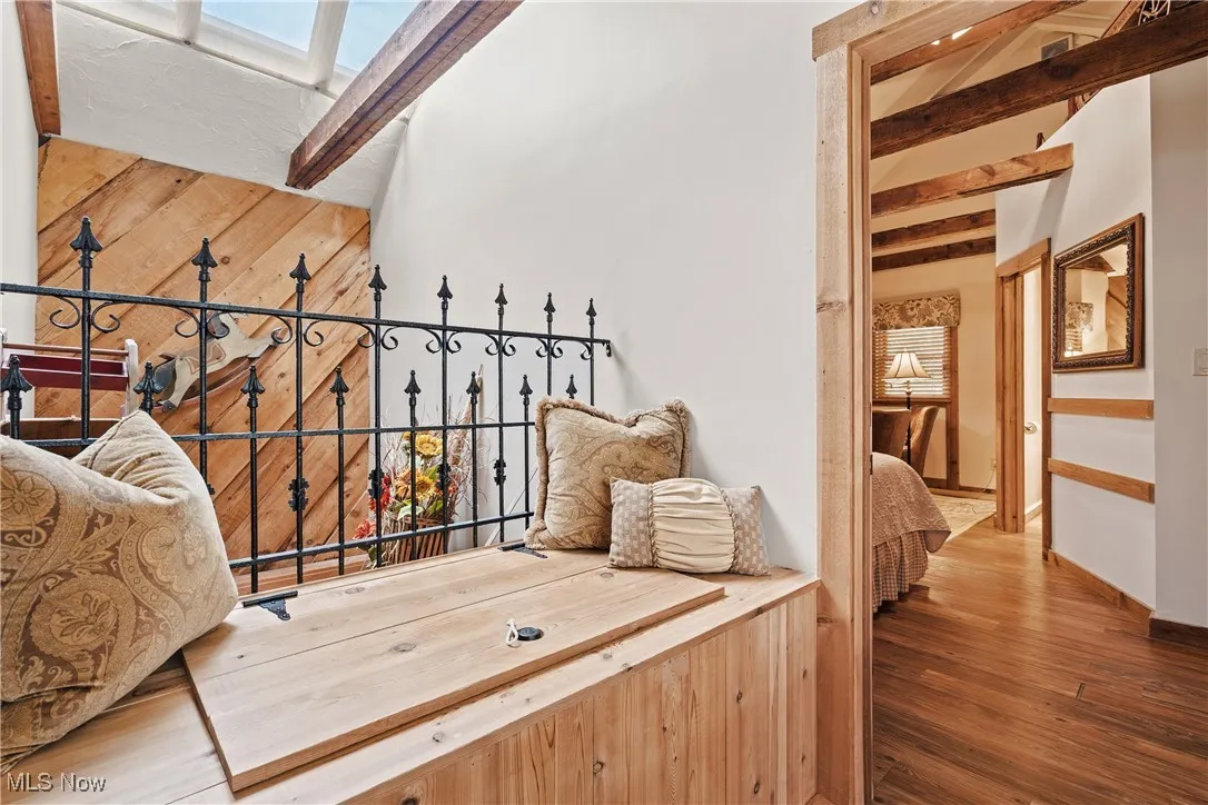 View of vaulted loft area of the front unit with storage bench, skylights, and original beams