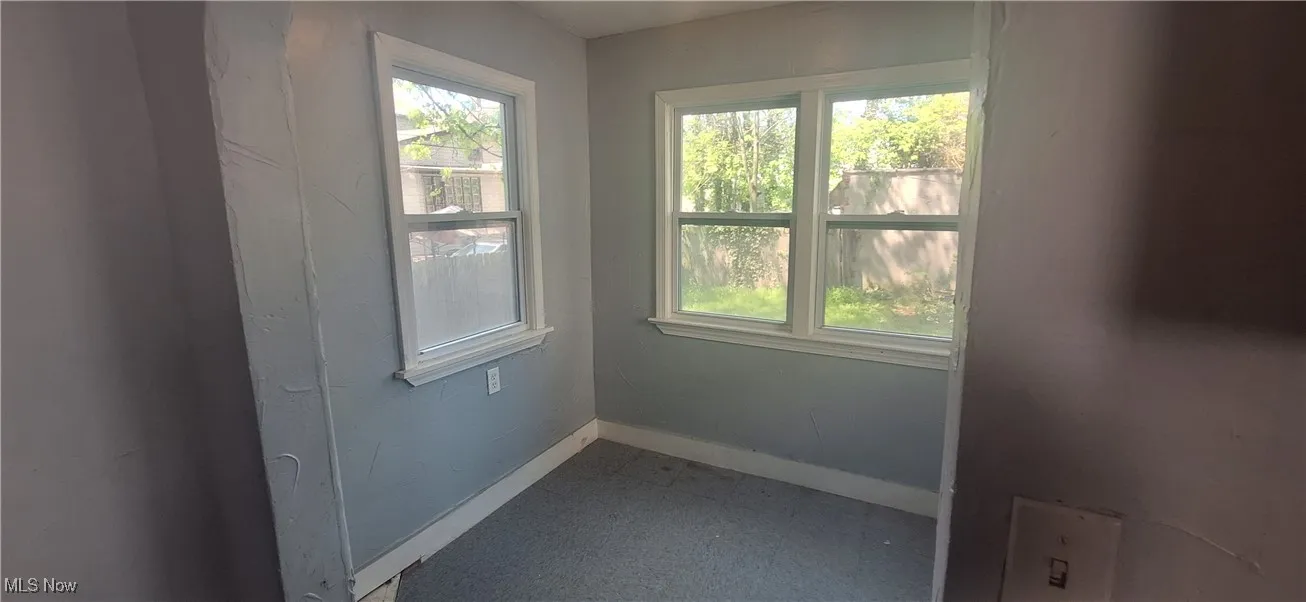 Empty room with baseboards and a healthy amount of sunlight