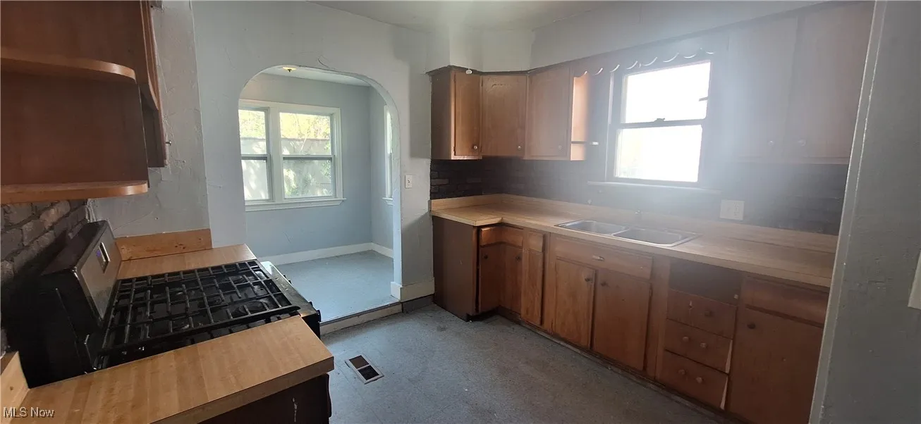 Kitchen with baseboards, decorative backsplash, a sink, and light​​‌​​​​‌​​‌‌​‌‌​​​‌‌​‌​‌​‌​​​‌​​ countertops