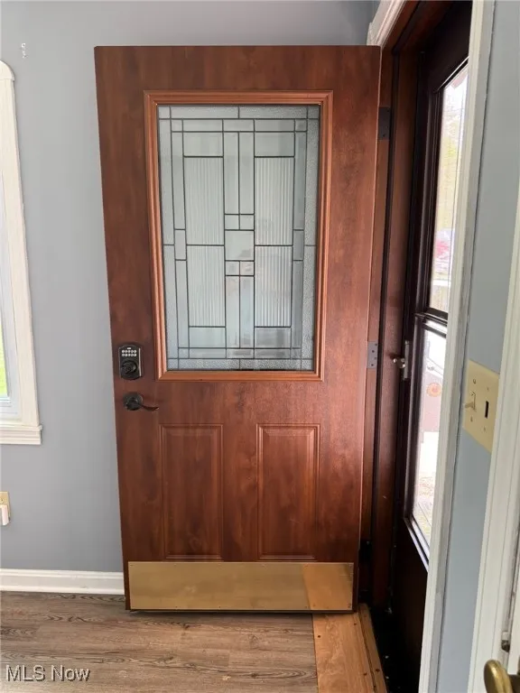 Doorway featuring baseboards and wood finished floors