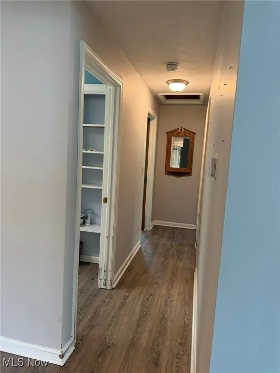 Hallway with baseboards and dark wood finished floors
