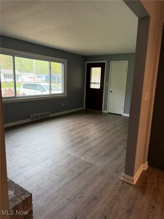 Entryway featuring baseboards, visible vents, a healthy amount of sunlight, and wood finished floors