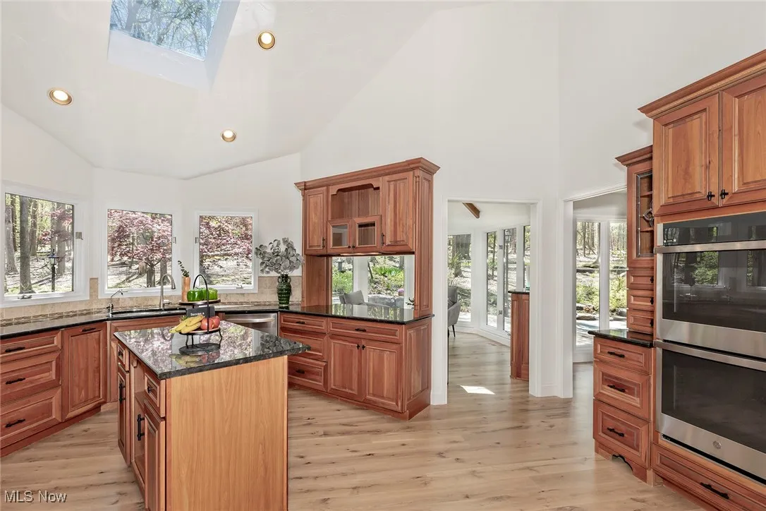 Kitchen with double oven, microwave, gas cooktop, LG stainless steel refrigerator plus wine refrigerator, disposal and dishwasher. Natural cherry cabinets , granite counters, and skylight. Note all the windows !