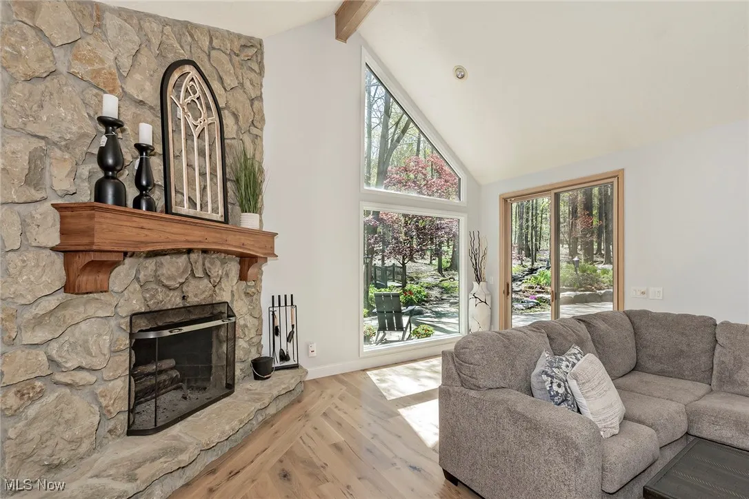 Family Room fireplace has a gas starter and a wonderfully rustic wood mantle. Beamed vaulted ceiling adds drama to this room. Pella sliding glass door leads to backyard paradise.