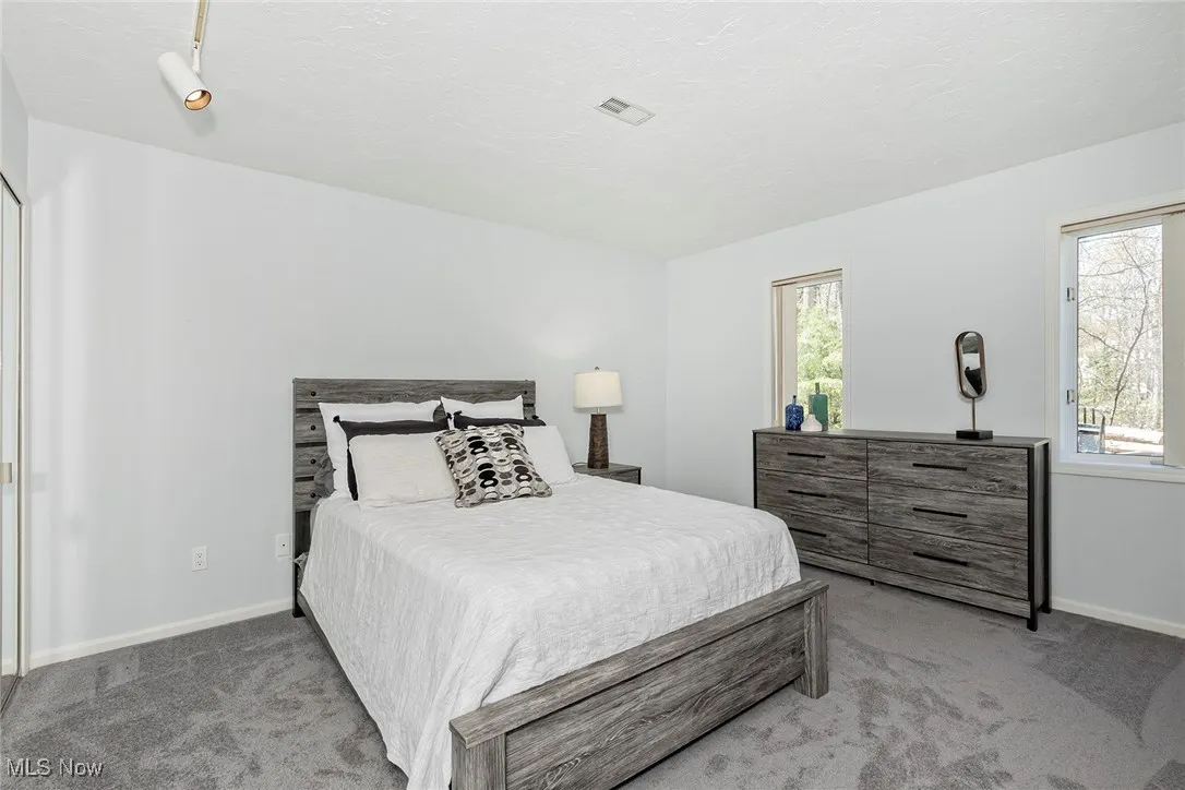 Three identical-sized bedrooms feature newer carpeting, large closets, and direct access to baths.